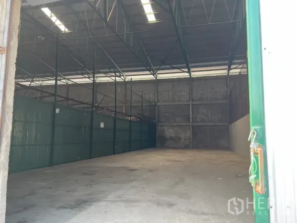 Warehouse for rent in Prawet, Bangkok - Spacious 300 sqm warehouse interior with high steel truss roof and concrete floor.