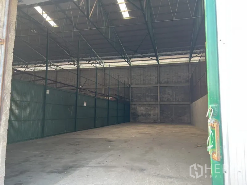Warehouse for rent in Prawet, Bangkok - Spacious 300 sqm warehouse interior with high steel truss roof and concrete floor.