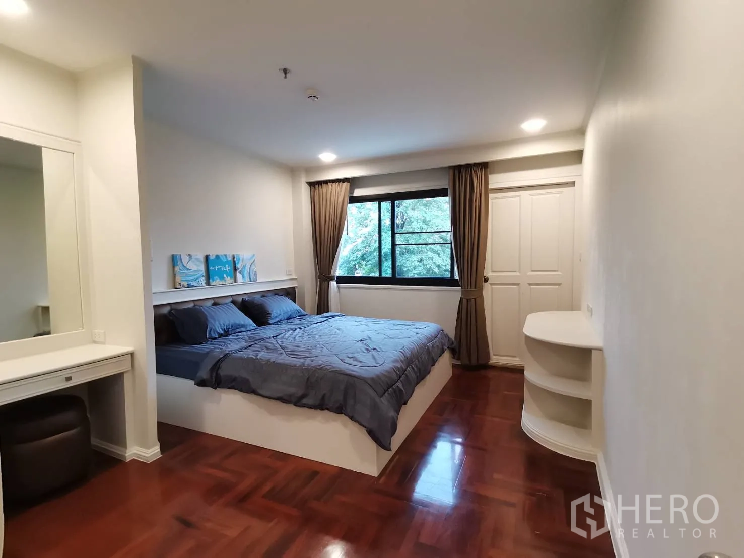 公寓 for rent in Watthana, Bangkok - 卧室配特大床，大窗望绿景，梳妆台与人字拼木地板。