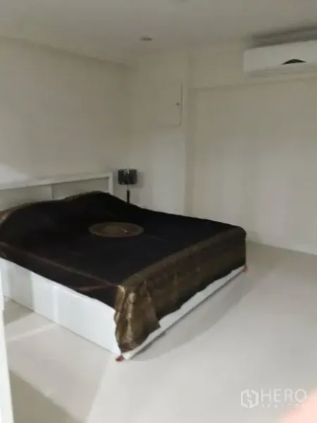 公寓 出租在Pathum Wan, Bangkok - 极简主卧，双人床、白墙与壁挂空调