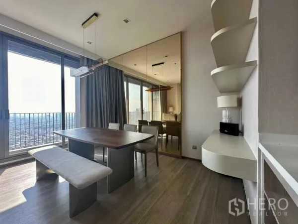 Condominium for rent in Bang Kho Laem, Bangkok - Dining area with bench seating beside sliding glass doors to the balcony and a mirrored feature wall.