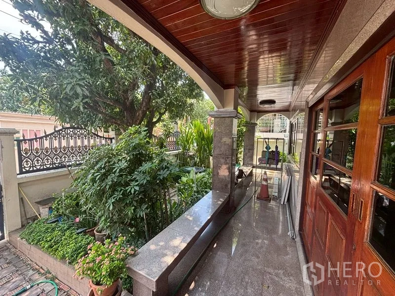 บ้านเดี่ยว for sale in Suan Luang, Bangkok - เฉลียงกว้างเพดานไม้พร้อมเสากรุหินและสวนร่มรื่น