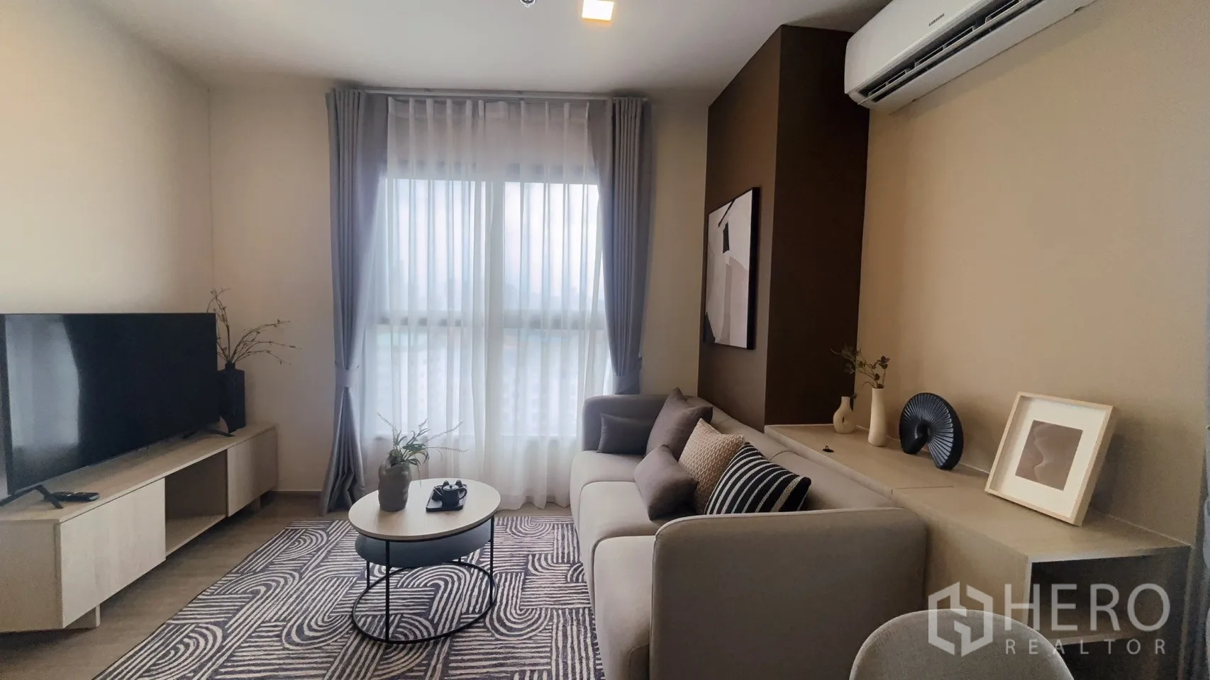 公寓 for rent in Watthana, Bangkok - 温馨客厅，沙发、圆形茶几、电视柜与通高窗。