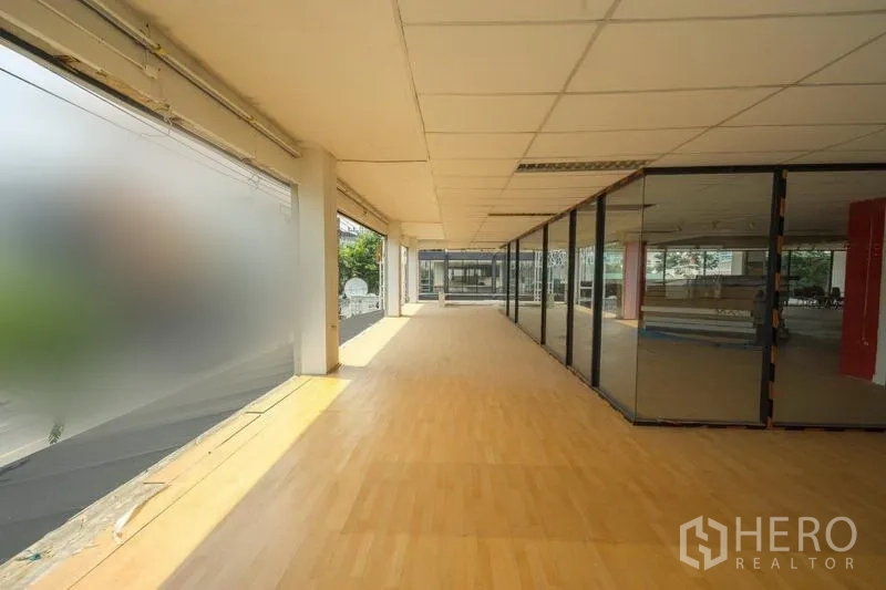Retail Space for rent in Watthana, Bangkok - Sunlit retail interior with wood floors, floor-to-ceiling windows and glass-partitioned rooms.