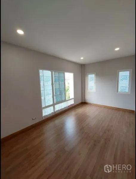 Detached House for sale in Bang Yai, Nonthaburi - Spacious bedroom with wood floors and large windows for abundant light