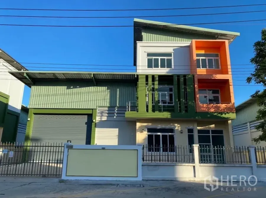 工厂 出租或出售在Lam Luk Ka, Pathum Thani - 工厂正立面全景，色彩鲜明的办公立面与围墙。