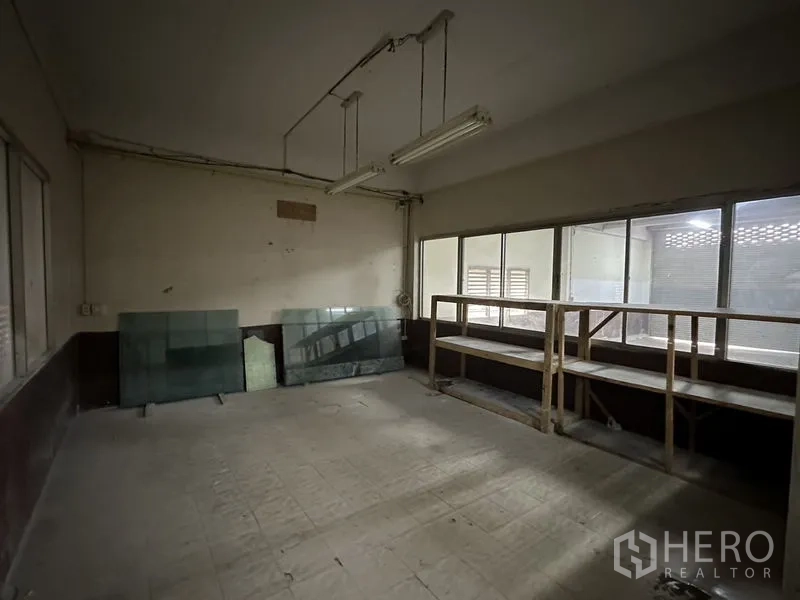 Factory for rent in Bang Bua Thong, Nonthaburi - Workshop room with shelving and windows beside the warehouse.