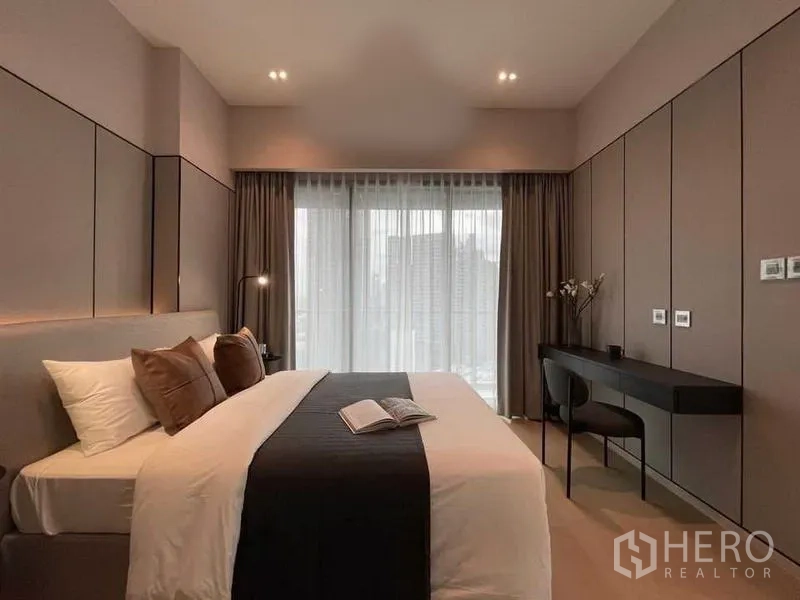 Condominium for rent in Watthana, Bangkok - Primary bedroom with large windows, a work desk, and a city outlook.