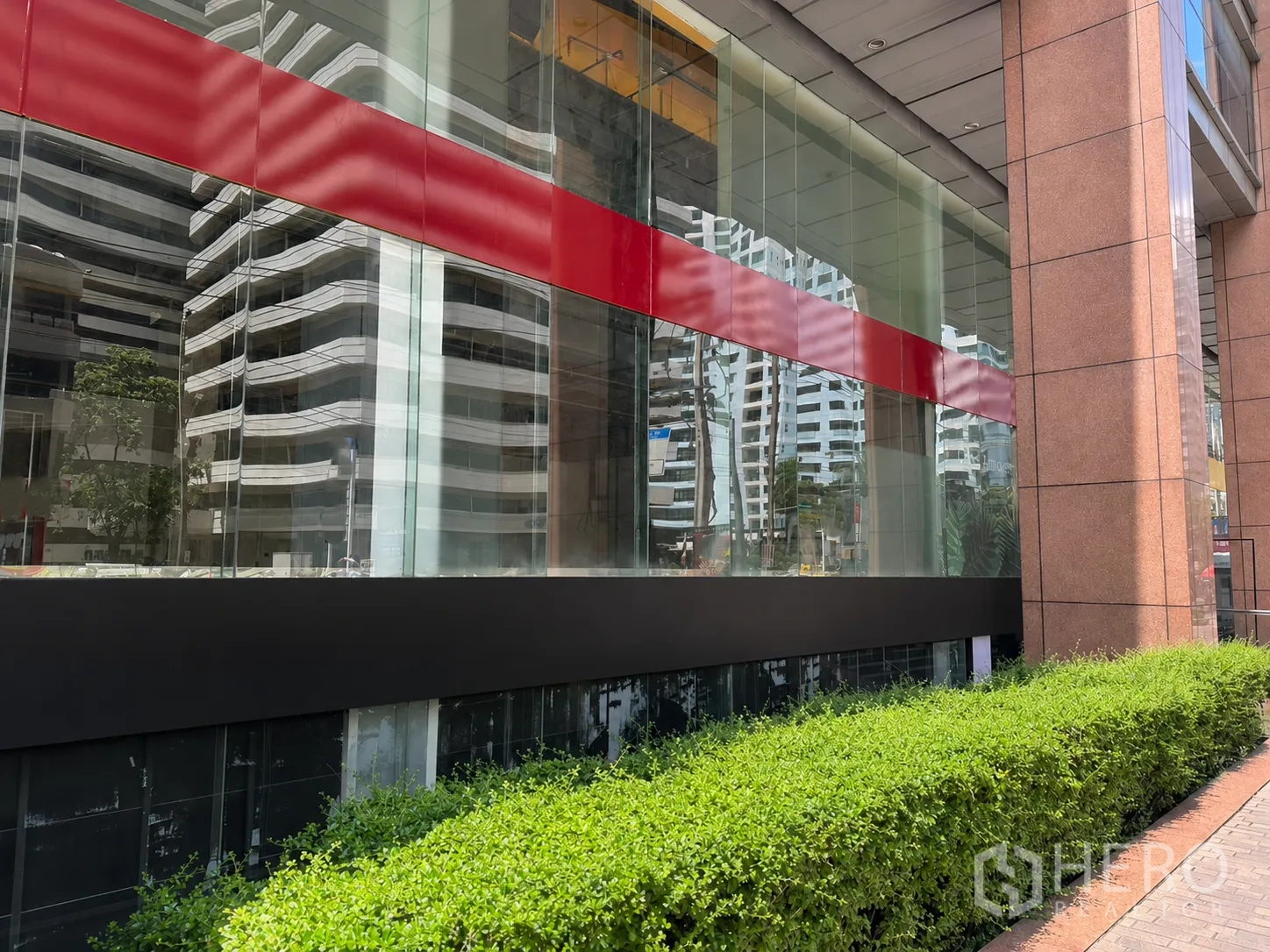 零售空间 for rent in Watthana, Bangkok - 建筑外立面大面积玻璃，绿篱步道与花岗岩立柱。