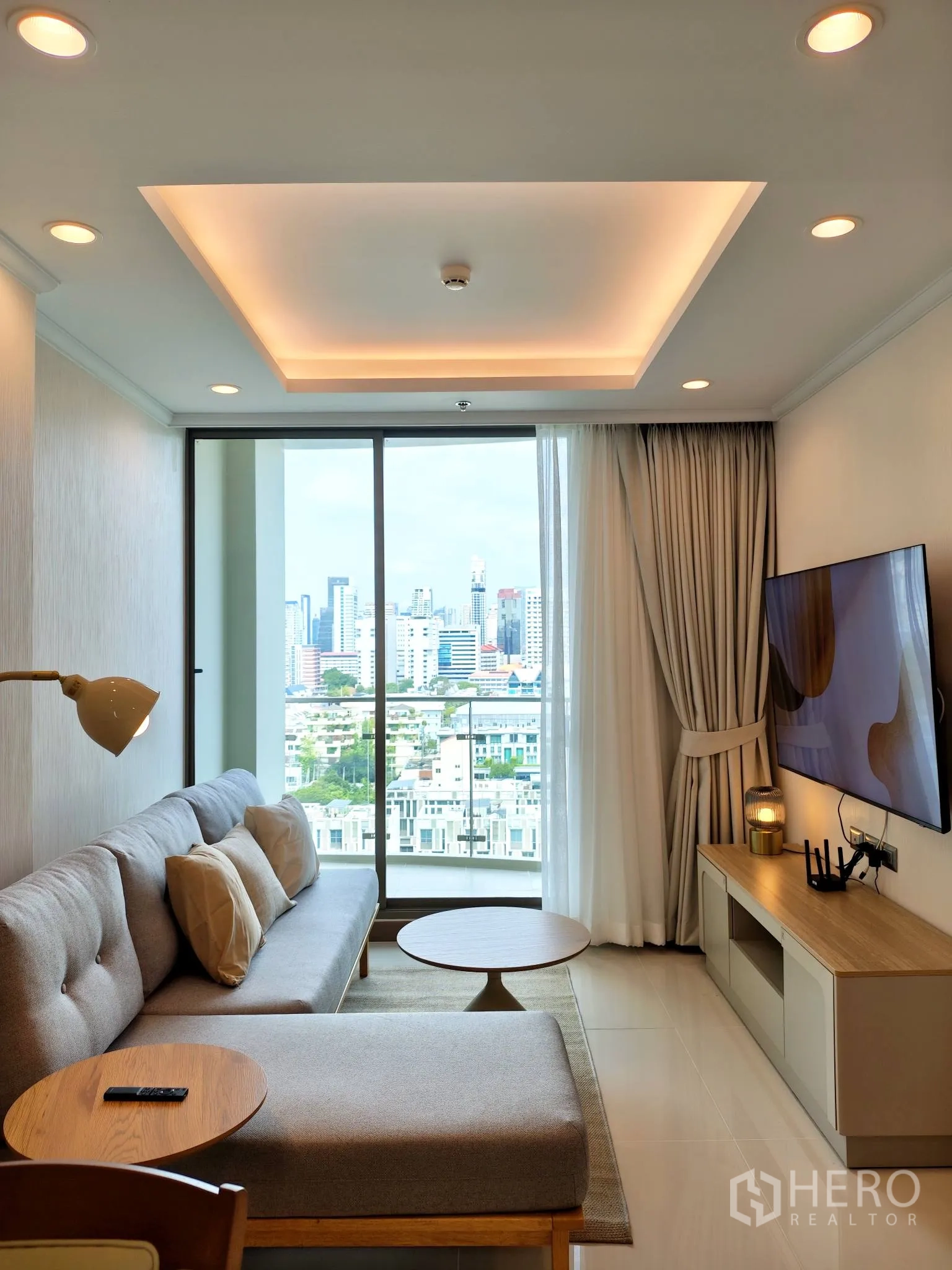 คอนโด for rent in Watthana, Bangkok - ห้องนั่งเล่นเชื่อมระเบียงมองเห็นวิวสกายไลน์และฝ้าหลุมพร้อมไฟซ่อน