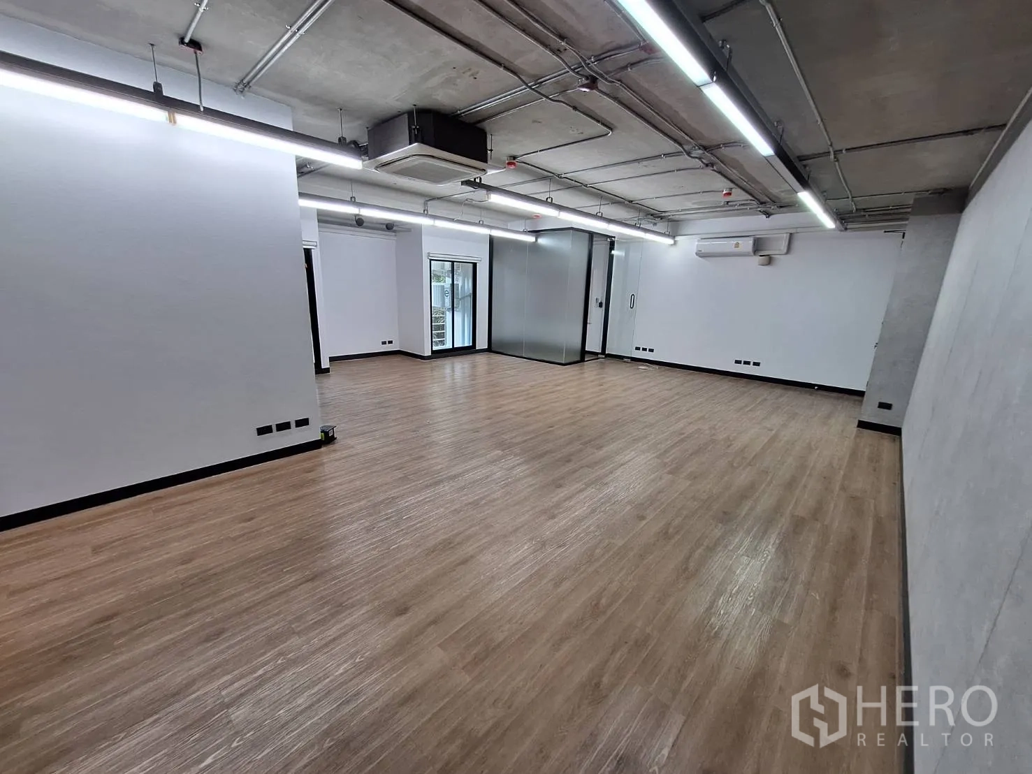 สำนักงาน ให้เช่า - พื้นที่ทำงานขนาดใหญ่ พื้นไม้โทนอ่อน และไฟเส้นยาว