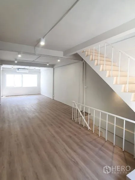Shophouse for rent in Phra Khanong, Bangkok - Long upper level with staircase, large front window and ceiling track lights.