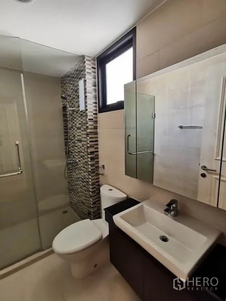 Townhouse for rent in Yan Nawa, Bangkok - Modern bathroom with glass-enclosed shower, mosaic wall tiles, and vanity.
