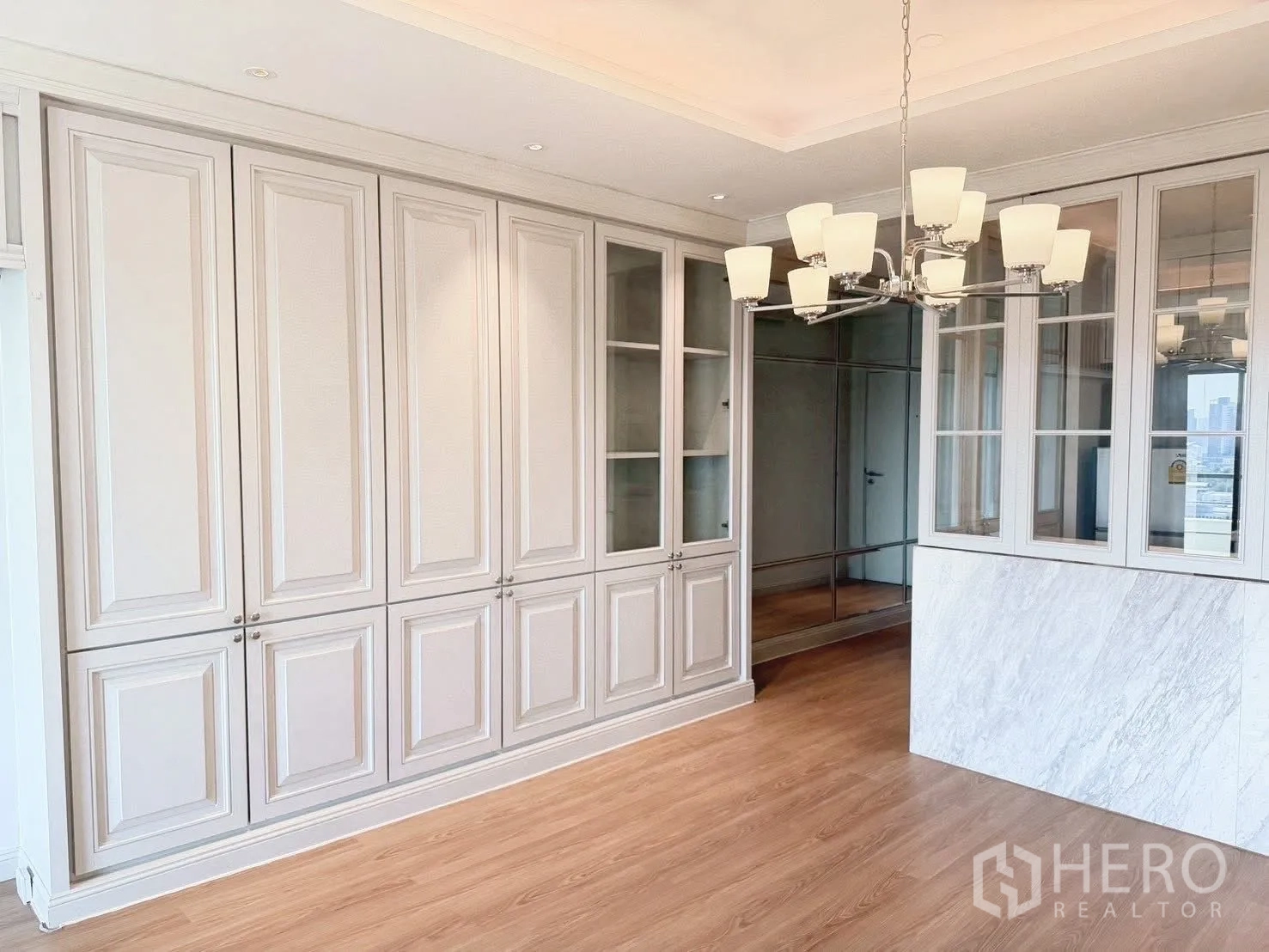 Condominium for rent or sale in Sathon, Bangkok - Dining area with soft-tone built-in cabinetry and chandelier.