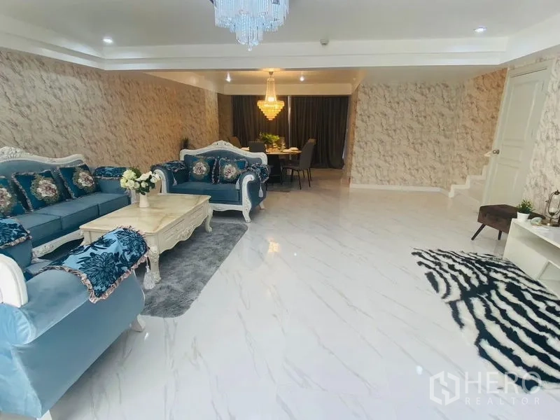 Condominium for rent or sale in Watthana, Bangkok - Another angle of the spacious lounge showing blue sofas and chandelier.