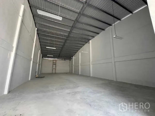 Warehouse for rent in Mueang Samut Sakhon, Samut Sakhon - Clean warehouse space with high metal roof, white walls, and even concrete floor.