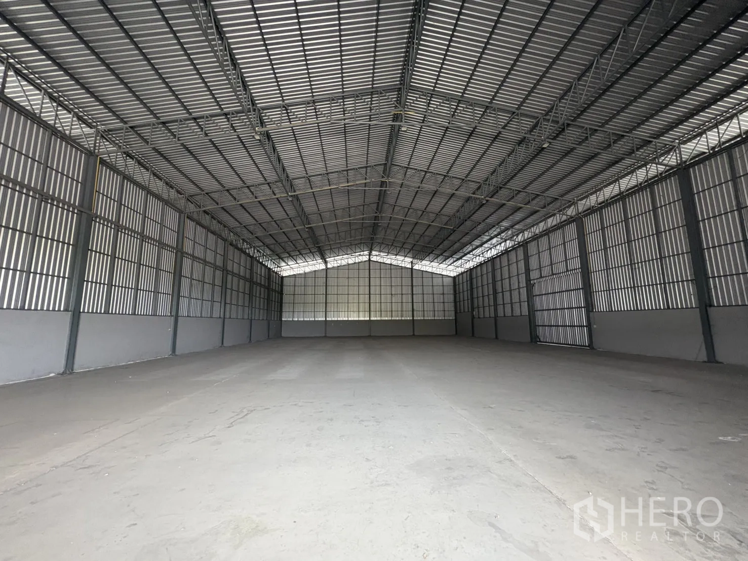 Warehouse for rent in Mueang Samut Prakan, Samut Prakan - Long view across the empty warehouse floor with tall corrugated walls and high ceilings.