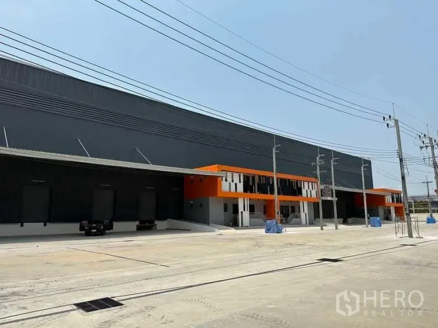 工厂 出租在Bang Phli, Samut Prakan - Bang Phli 保税区现代厂房外观，橙色立面与宽阔装卸场地。