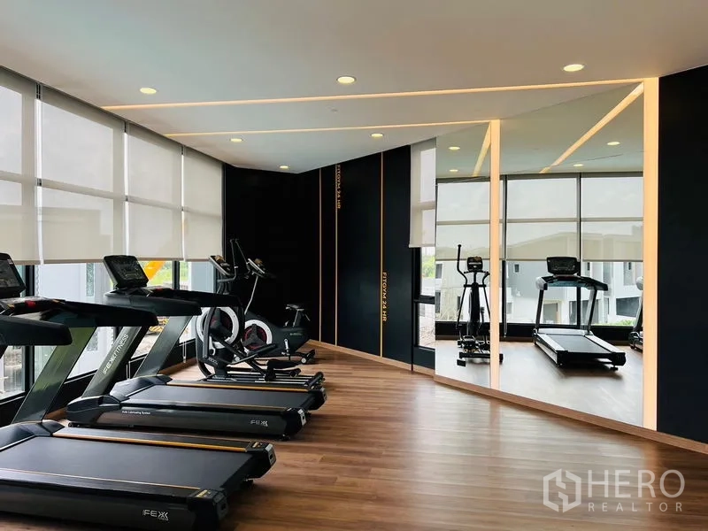 Townhouse for rent - Residents’ fitness room with treadmills, exercise bikes, wall mirrors and wood floors.