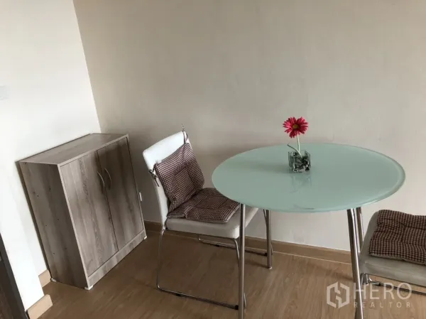 公寓 出租在Khlong Toei, Bangkok - 小型用餐角落，圆形玻璃餐桌、两把座椅与木质小柜。