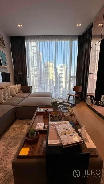 公寓 出售 - 温馨起居角，咖啡桌与高帘，框出城市景。