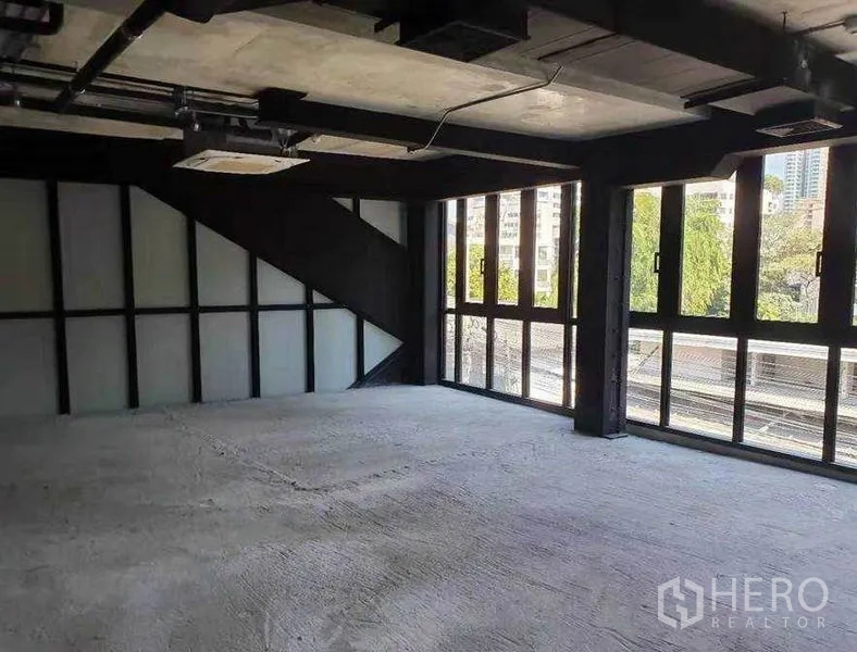 Retail Space for rent in Watthana, Bangkok - Corner retail area with floor-to-ceiling windows, city outlook and industrial concrete ceiling.