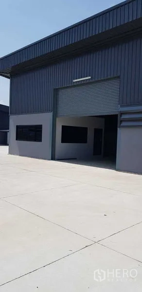 货栈 出租在Lat Lum Kaeo, Pathum Thani - 现代金属外墙仓库，配大卷帘门与宽阔混凝土场地。