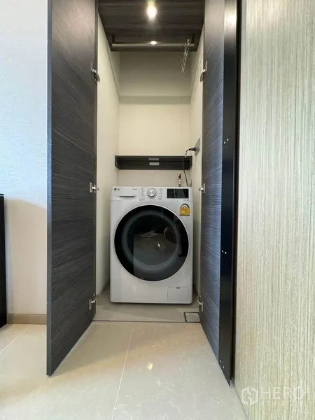 公寓 出租在Watthana, Bangkok - 内置柜体中的滚筒洗衣机，方便收纳与使用。