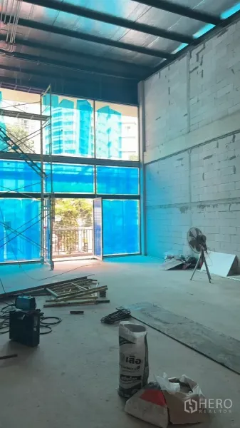零售空间 出租在Khlong Toei, Bangkok - 开放式单元，超高窗、脚手架与未完工地面