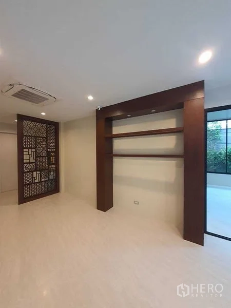 บ้าน ขายในPrawet, Bangkok - ห้องพักผ่อนมีชั้นไม้ ฉากกั้น และประตูออกสู่สวน