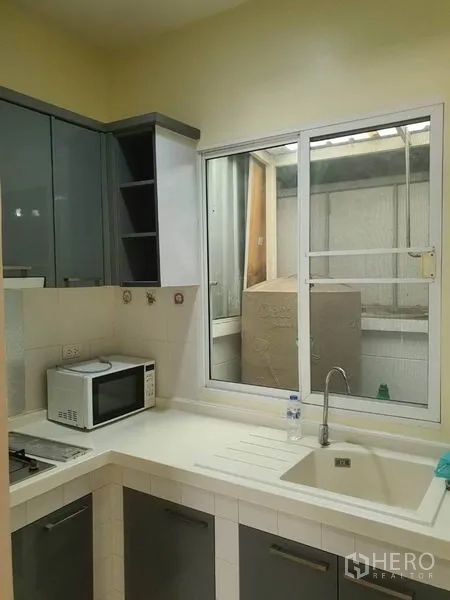 联排别墅 出租在Wang Thonglang, Bangkok - 紧凑厨房，柜体、水槽、炉灶与窗户