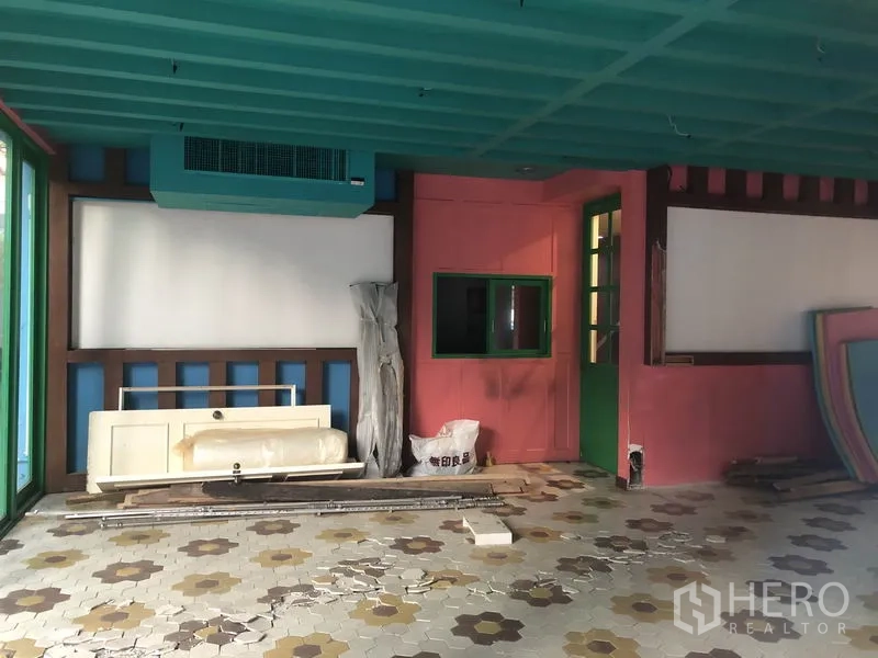 Retail Space for rent in Khlong Toei, Bangkok - Vacant retail interior with teal ceiling, pink walls, patterned tile floor and stored fit‑out materials.
