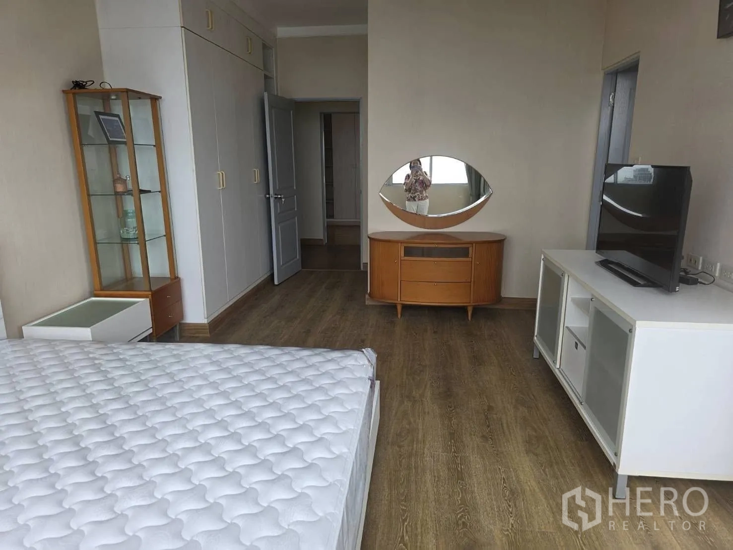 Condominium for rent in Khlong Toei, Bangkok - Master bedroom corner with glass display cabinet and TV stand.
