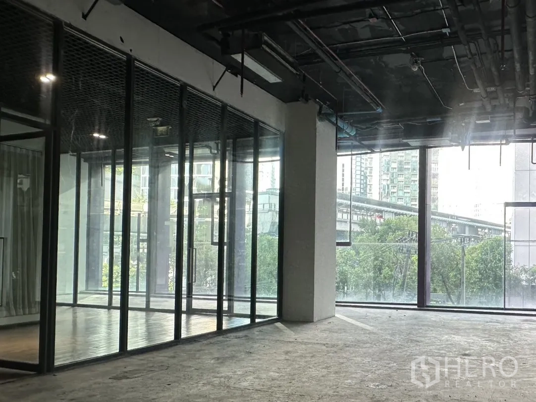 零售空间 for rent in Khlong Toei, Bangkok - 转角区域配长幅玻璃门面，可见城市景观。