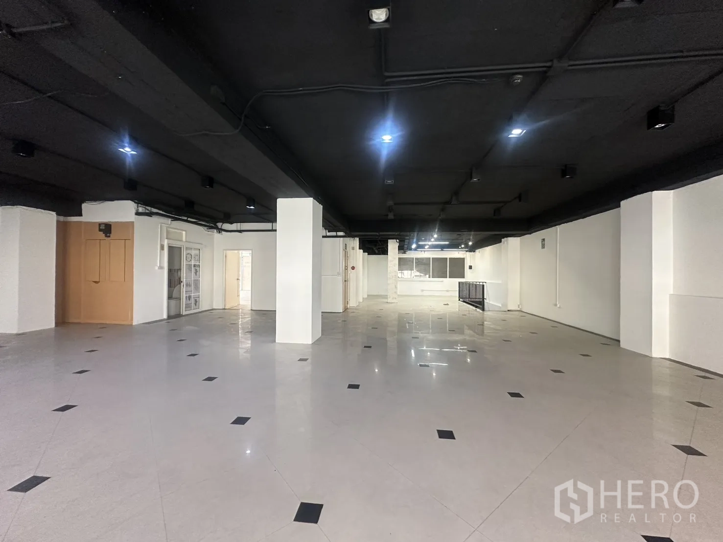 Retail Space for rent in Pathum Wan, Bangkok - Large open mezzanine with a black ceiling and structural columns.