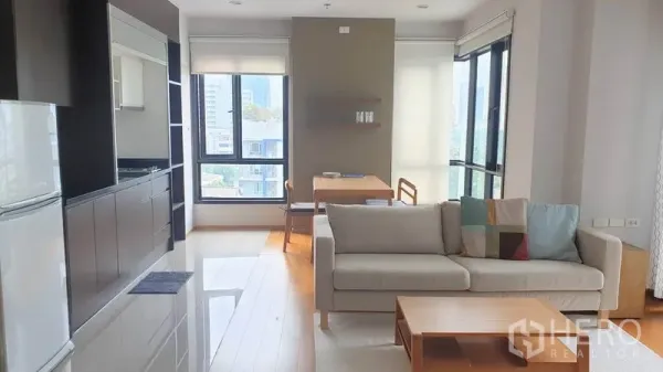 公寓 出租在Phaya Thai, Bangkok - 明亮的客厅，开放式厨房、木地板与城市景观落地窗，位于Ari一带的公寓。