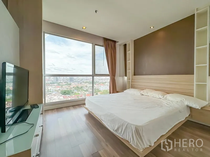 Condominium for sale - Master bedroom with king bed, TV stand and floor-to-ceiling windows over the city.