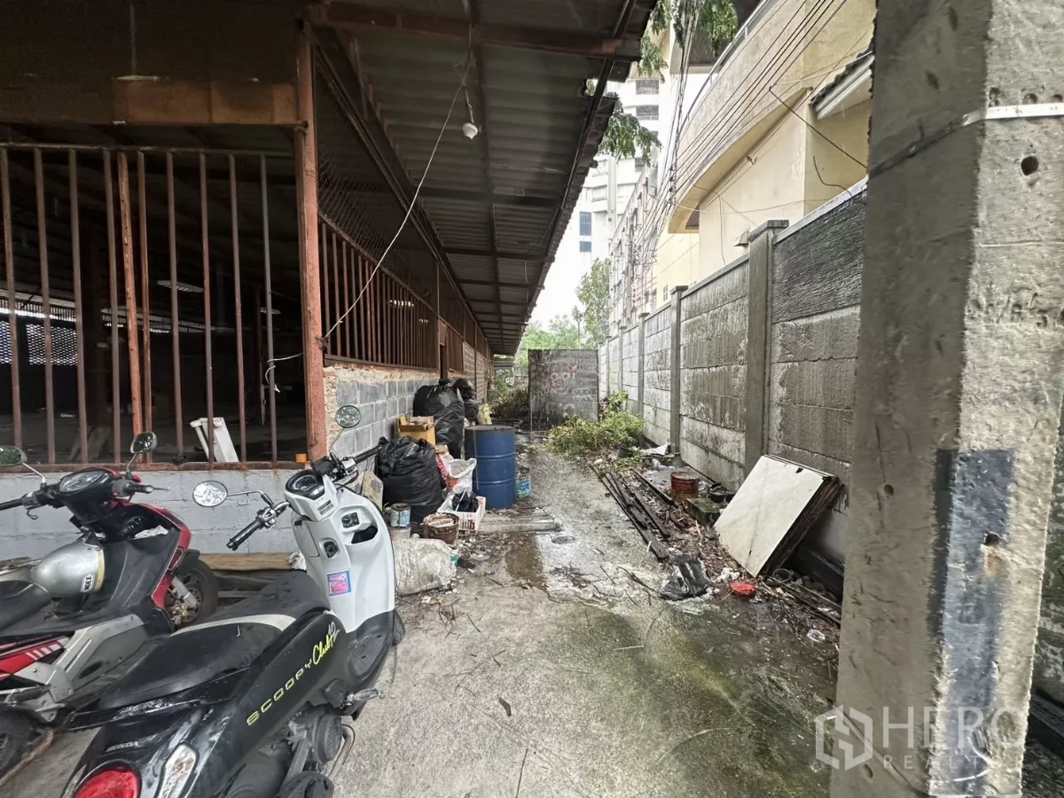 คลังสินค้า ให้เช่าหรือขายในYan Nawa, Bangkok - ทางเดินบริการข้างอาคาร หลังคาเมทัลชีท กำแพงอิฐบล็อก พร้อมมอเตอร์ไซค์จอด