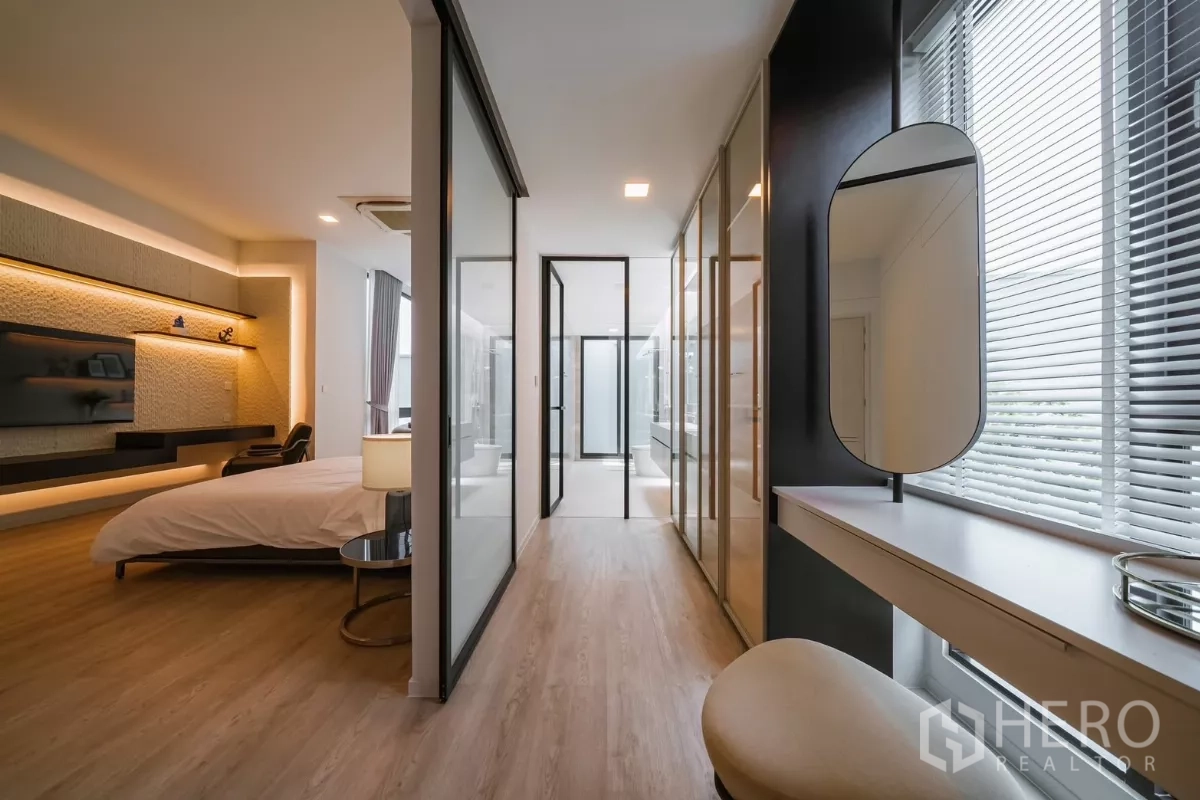Detached House for rent or sale in Saphan Sung, Bangkok - Master suite corridor with wardrobes, makeup desk and glass doors to bathroom.