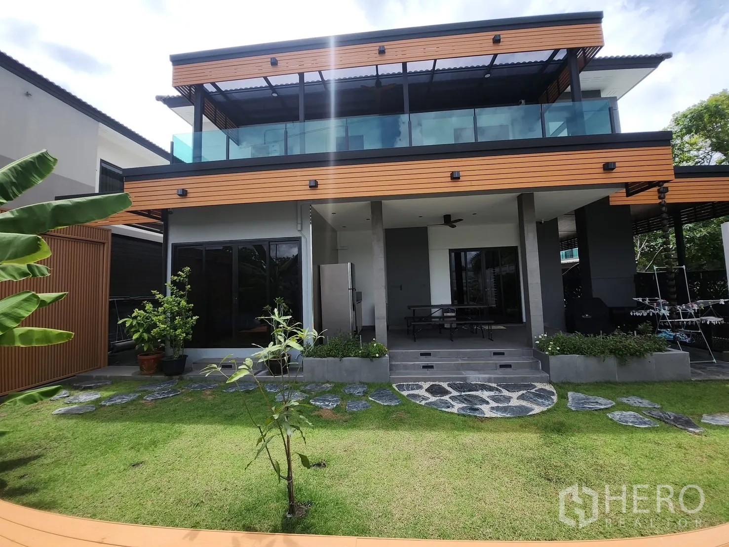 บ้าน ให้เช่าในBang Phli, Samut Prakan - ด้านหลังบ้านมีระเบียงชั้นบน สนามหญ้า และประตูบานเลื่อนกระจก