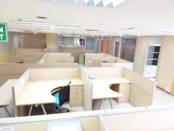 Office Space for rent - Bright open-plan office level with many workstations, ceiling lights and an exit sign.