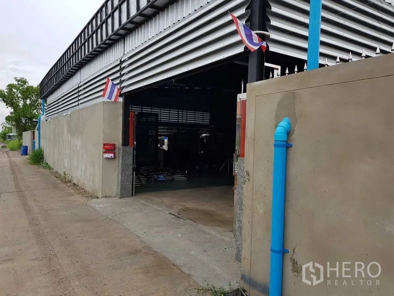 Warehouse for sale in Lam Luk Ka, Pathum Thani - Entrance to the warehouse showing the open loading bay and concrete driveway.