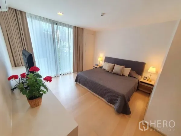公寓 出租在Watthana, Bangkok - 主卧设特大床、床头灯与落地窗