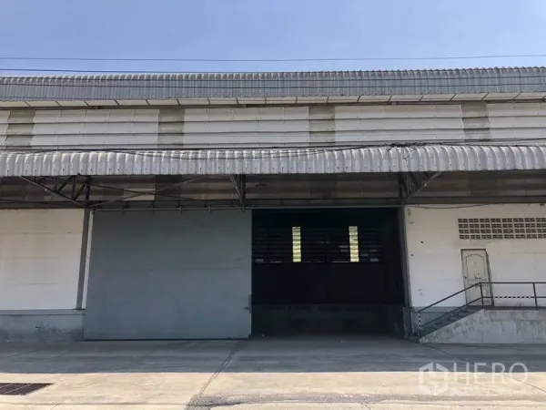 货栈 出租在Khlong Luang, Pathum Thani - 带雨棚的升高装卸月台，卷闸门与坡道出入口。