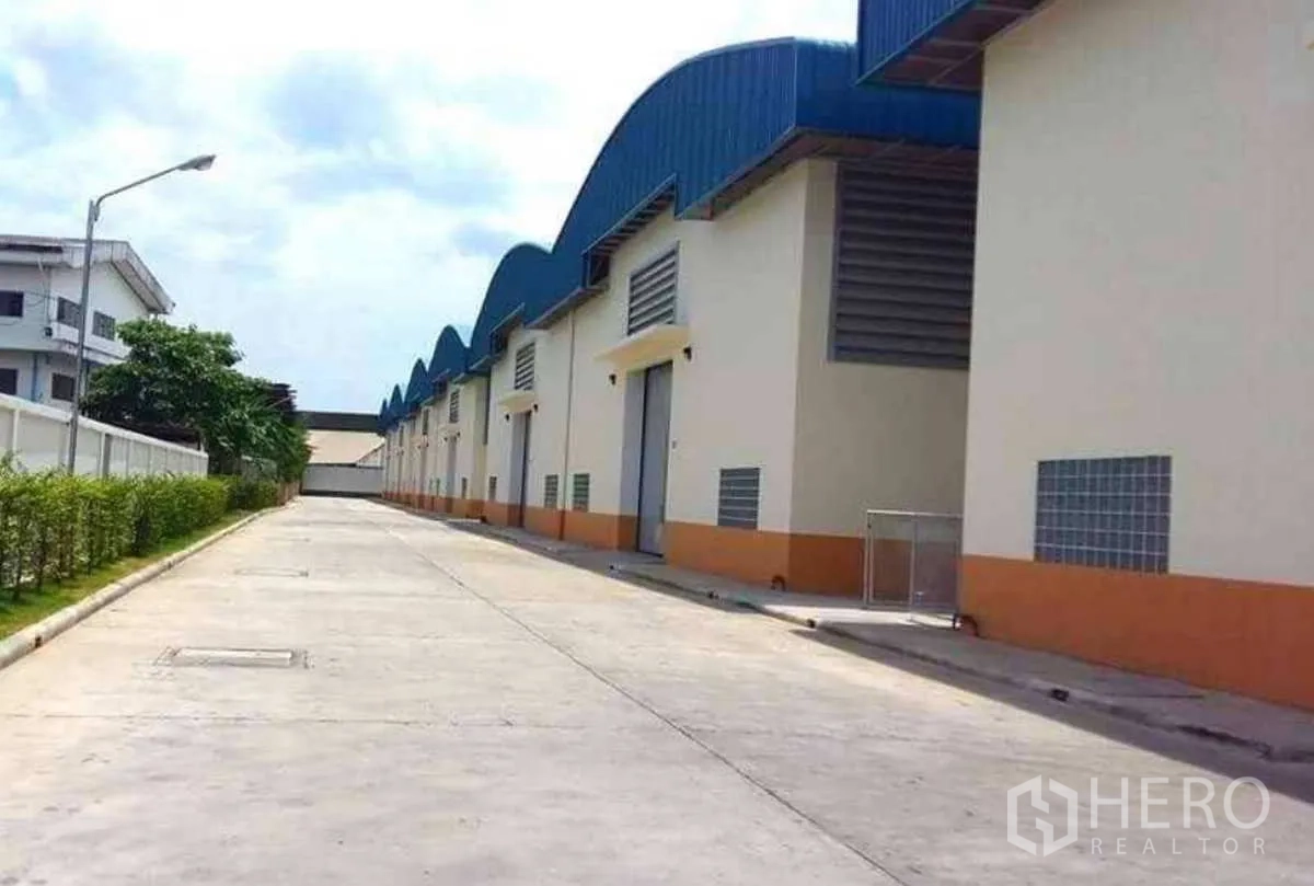 โรงงาน ให้เช่าในKrathum Baen, Samut Sakhon - อาคารโรงงานเรียงกัน หลังคาทรงคลื่นสีน้ำเงิน ถนนคอนกรีตกว้างรองรับรถบรรทุกในกระทุ่มแบน