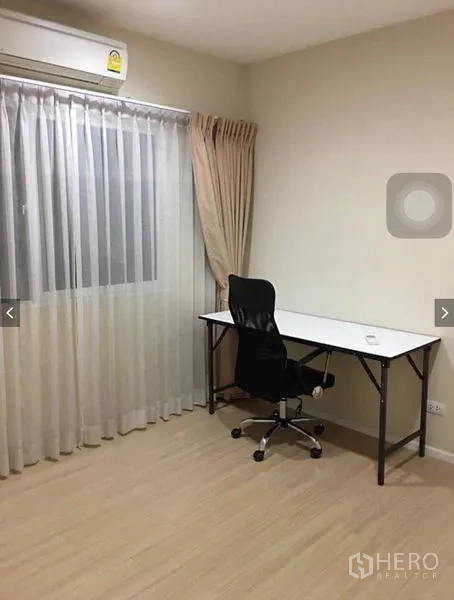 Townhouse for rent or sale in Suan Luang, Bangkok - Quiet study room with desk, office chair, air-conditioning, and sheer curtains.