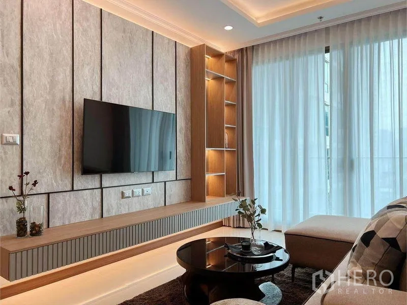 คอนโด ให้เช่าในWatthana, Bangkok - มุมมองห้องนั่งเล่น แสดงผนังทีวีบิลต์อิน ชั้นไฟ และประตูกระจกพร้อมผ้าม่านโปร่ง