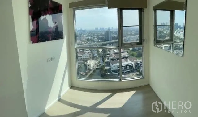 Condominium for sale in Khlong Toei, Bangkok - Corner room with floor-to-ceiling windows and abundant natural light over the city.
