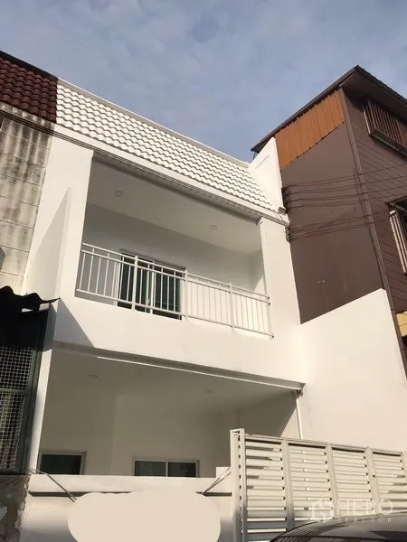 สำนักงานที่บ้าน ให้เช่าหรือขายในPhra Khanong, Bangkok - ด้านหน้าอาคารทาวน์โฮมสีขาวสมัยใหม่ พร้อมระเบียงและรั้วหน้าบ้าน