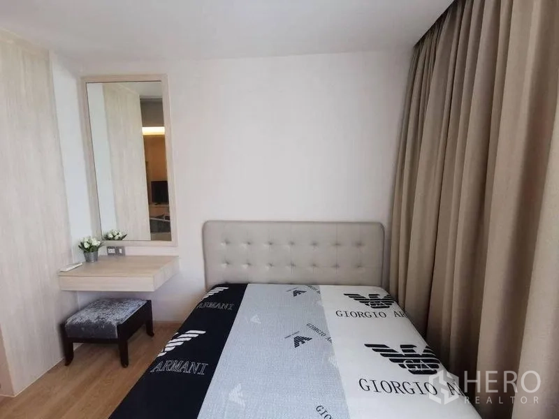 Condominium for rent or sale in Watthana, Bangkok - Cozy bedroom with upholstered headboard, vanity and full-length curtains in neutral tones.